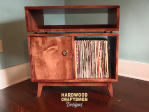 Solid maple record player stand with a turntable shelf, media bay, 1 lower door, 2 storage bins, and tapered mcm legs.