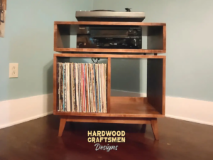 Low-profile solid maple mid-century media console with a TV shelf, turntable compartment, equipment shelving, and two divided storage sections.
