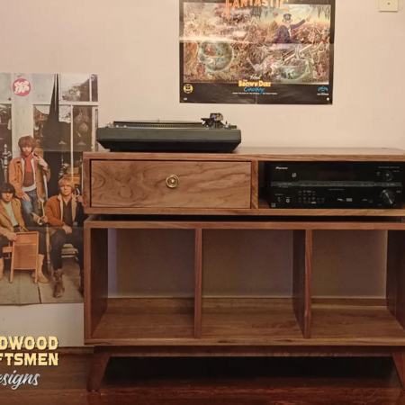 Solid walnut record player stand with a dovetail drawer and 3 vinyl storage bin compartments, available from 42 to 72 inches. This Media console features an upper TV shelf above three divided compartments, all on tapered mid-century legs.