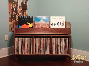 Large solid maple record cabinet with 3 upper vinyl flip bins, three divided storage compartments, and tapered mid-century legs with crossbars.