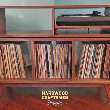 Record player cabinet featuring 3 vinyl storage divided compartments with a turntable pull out shelf and equipment bay above. This media console tv stand in solid walnut is available from 42 to 72 inches, all on tapered mid-century legs.
