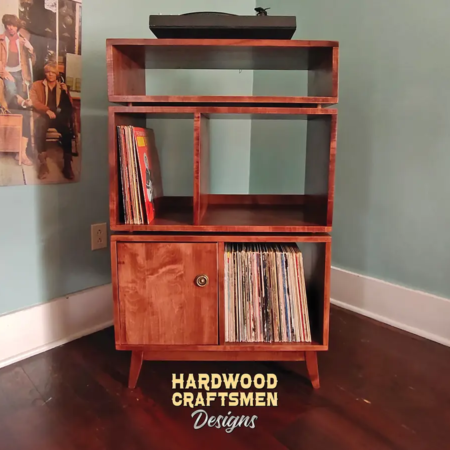 Tall 2x3 solid wood record stand featuring a turntable shelf with a media compartment below, four storage compartments with one lower door on the left, and tapered mid-century legs.