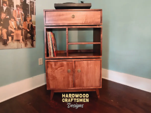 Large 2x3 solid wood record stand featuring a turntable shelf with a dovetail drawer below, four storage compartments with two lower doors, and tapered mid-century legs.