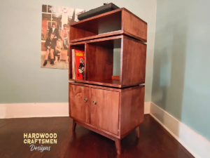 Large 2x3 solid hardwood record stand featuring a turntable shelf with a media bay below, four storage compartments with two lower doors, and tapered mid-century legs.