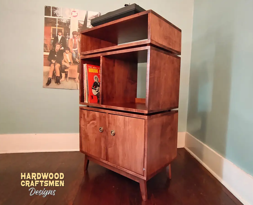 Record player cabinet 2 x 3 with 2 doors featuring a turntable shelf with a media bay below, four storage compartments, and tapered mid-century legs.