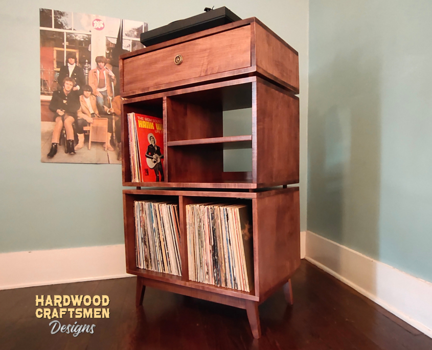 Solid maple record cabinet with upper turntable shelf, modular dovetail drawer, four divided storage compartments, media equipment shelves, and tapered mid-century legs.