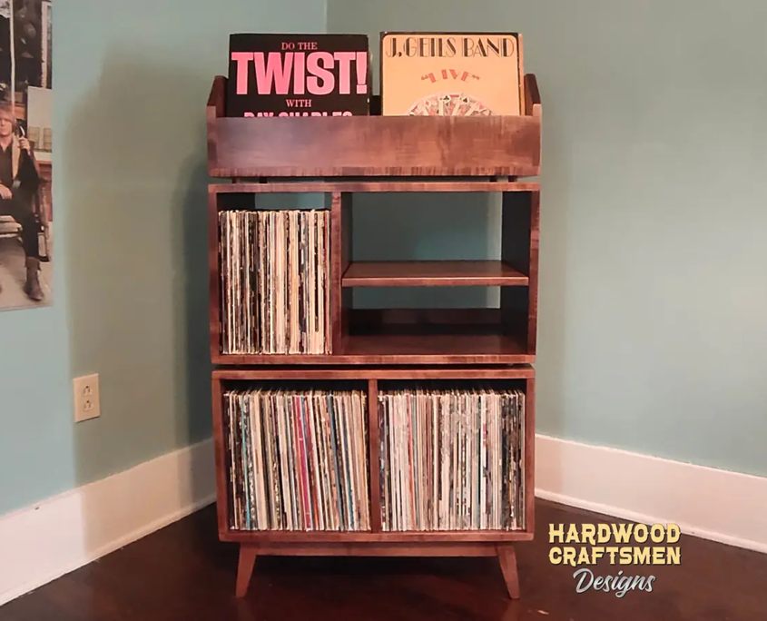 Solid maple record cabinet, 28 - 72" inches wide, featuring two vinyl flip bins above four storage compartments arranged on two levels, all on tapered mid-century legs.
