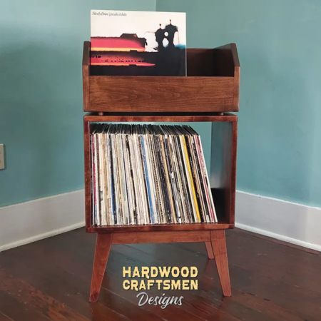 1x2 solid cherry record stand with upper vinyl record flip bin, one hardwood vinyl storage compartment, and tapered mid-century legs with crossbars.