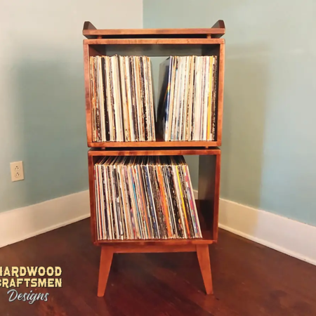 Record stand built of solid wood, in medium brown finish with two vertical storage bins, custom shelf for turntable.