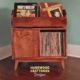 Solid maple vinyl storage cabinet with doors 2-tier with 2-to-4 LP flip bin compartments, available from 28-to-56-inches. This record stand features upper forward facing bins above 2-to-4 divided compartments, all on tapered mid-century legs.