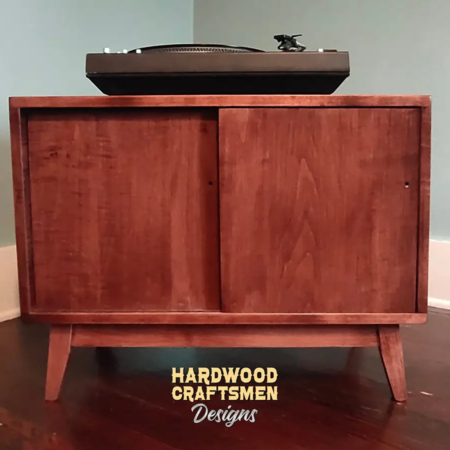 Low profile solid cherry 1 x 2 vinyl record storage featuring an upper turntable and media equipment shelf. The lower section includes a media cabinet with two sliding doors and two divided storage compartments.