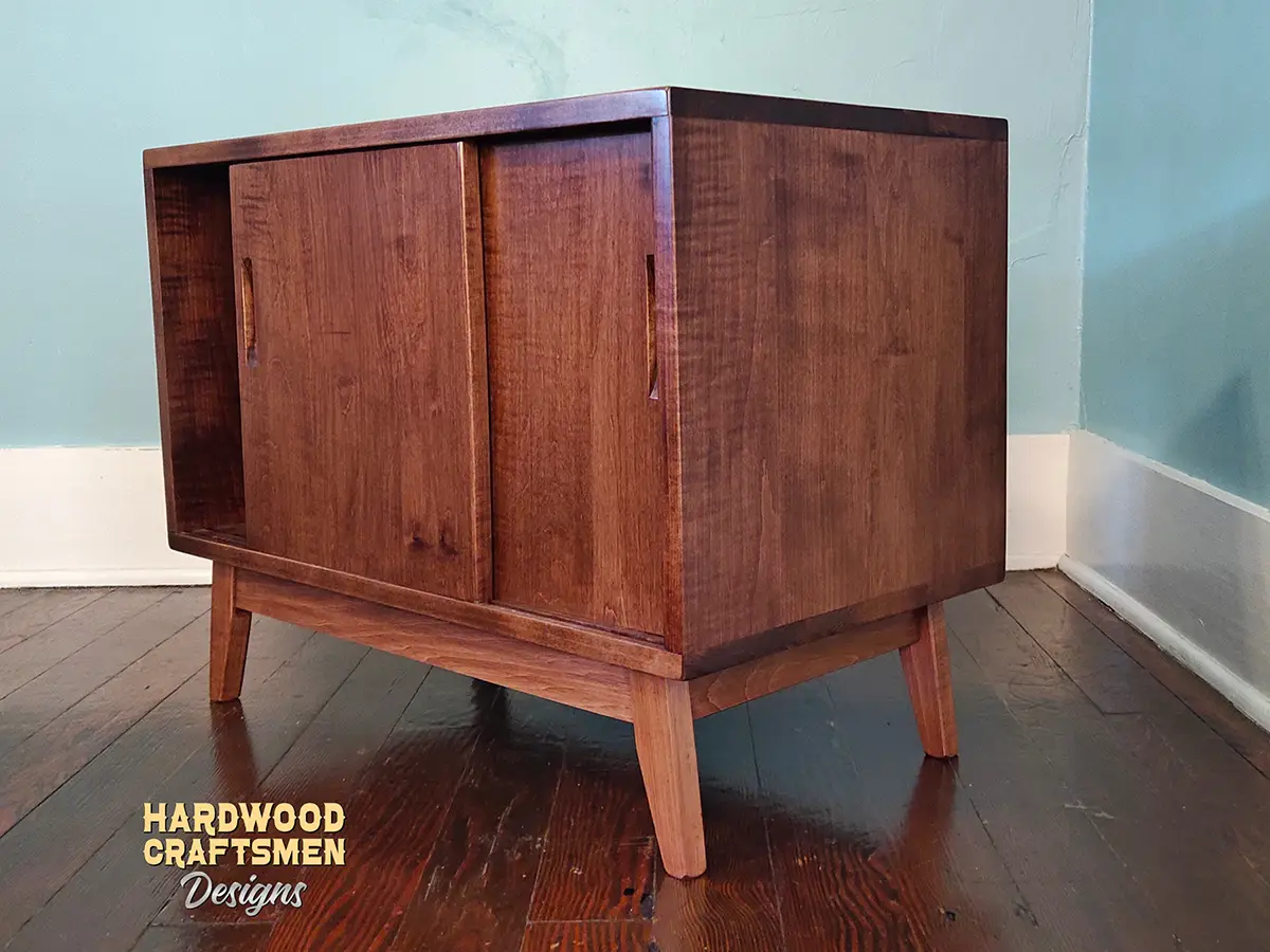 Solid cherry wood record cabinet featuring an upper turntable and media equipment shelf. The lower section includes a media cabinet with two sliding doors and two divided storage compartments.