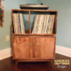 Large solid maple record cabinet, available from 28 to 48 inches wide, featuring an upper turntable shelf. Below are four storage compartments with two bottom doors, all on tapered mid-century legs.
