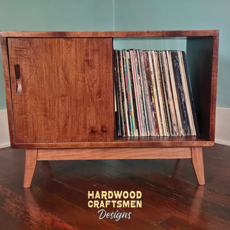 Solid cherry record player cabinet with a turntable shelf, 2 storage bins, 2 sliding doors, and tapered wooden legs.