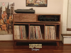 2-Level solid walnut media console featuring a turntable shelf, a media bay, a dovetail drawer, three open storage bins, and tapered mid-century legs.