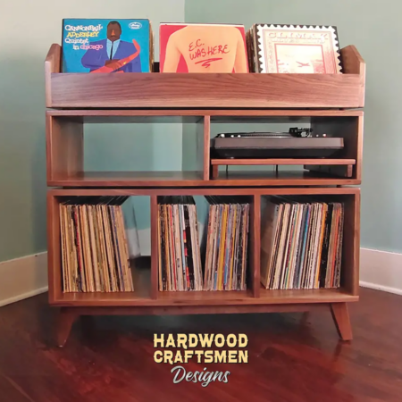 Record player cabinet in solid walnut features 3-to-5 storage compartments below 3-to-5 LP flip bins. This vinyl stand 3-tier is available from 42-to-70-inches, all on tapered mid-century legs.