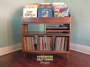 Large solid walnut record cabinet with nine vinyl flip bins, custom pull-out turntable shelf, three open storage compartments, and tapered mid-century legs.