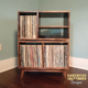 Large 2x2 solid wood record stand featuring a turntable and media shelves, four open vinyl storage compartments, and tapered mid-century legs.