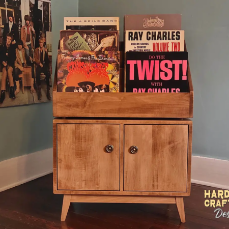 Large solid maple record cabinet with 6 vinyl flip bins, 2 storage compartments, 2 hinged doors, and tapered wooden legs.