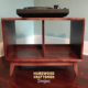 Low profile solid cherry 1 x 2 vinyl record storage cabinet featuring an upper turntable and media equipment shelf. The lower section includes a media cabinet with two open divided storage compartments, supported by tapered mid-century legs.