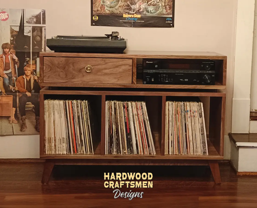 Solid walnut media console with drawers 3 x 1.5 with 3 vinyl storage bin compartments, available from 42 to 72 inches. This record player stand & cabinet features an upper TV shelf above three divided compartments, all on tapered mid-century legs.