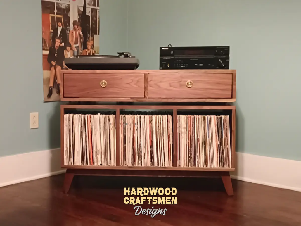 Solid walnut media console, available from 42 to 72 inches, featuring an upper TV shelf. Below are two drawers above three divided storage compartments, all on tapered mid-century legs.