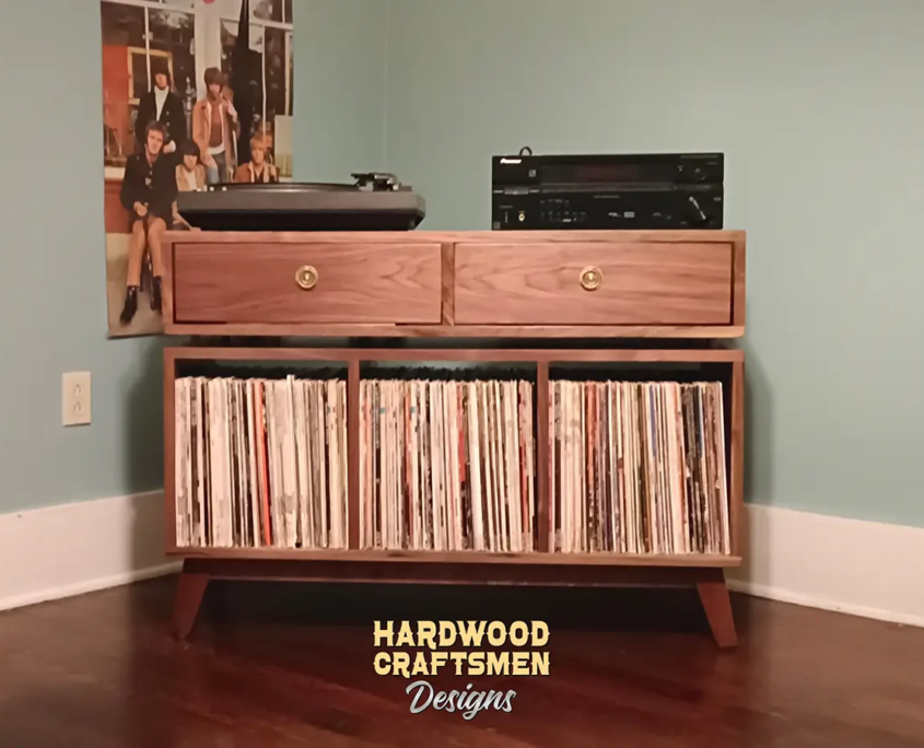 Large solid walnut media console, available from 42 to 72 inches, featuring an upper TV shelf. Below are two drawers above three divided storage compartments, all on tapered mid-century legs.