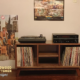 3X1 low-profile solid walnut media console with upper TV stand shelf, turntable and media equipment shelves, three divided storage compartments, and tapered mid-century legs.