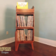 Narrow solid maple record stand with upper vinyl flip bin, two divided storage compartments, one lower hardwood door, and tapered mid-century legs.