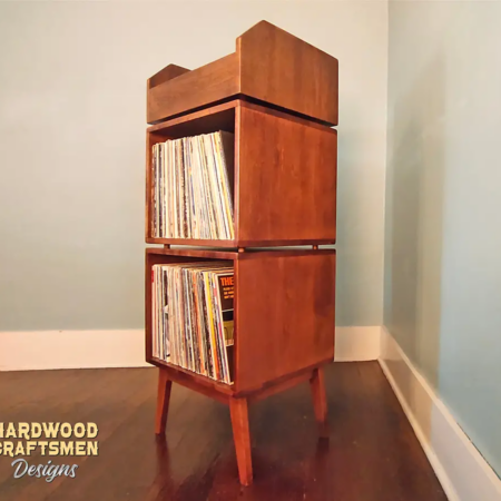 Tall solid cherry record cabinet with upper vinyl record flip bin, two stacked storage compartments, and tapered mid-century legs.