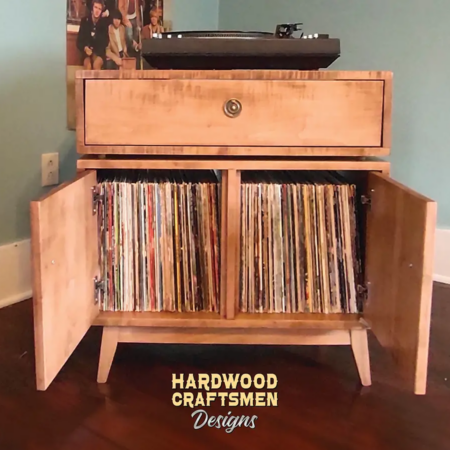 Record storage cabinet with dovetail drawers, turntable stand media console build with solid maple wood featuring an upper turntable shelf. The lower section includes a storage drawer above two open doors that reveal side-by-side storage compartments, all supported by tapered mid-century legs.