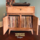 Record storage cabinet with dovetail drawers, turntable stand media console build with solid maple wood featuring an upper turntable shelf. The lower section includes a storage drawer above two open doors that reveal side-by-side storage compartments, all supported by tapered mid-century legs.