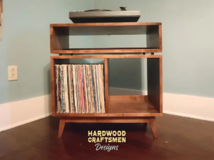 Low-profile solid wood record console with a turntable shelf, media bay, 2 storage cubbies, and tapered mcm legs.