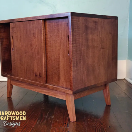 Solid cherry wood audio storage cabinet featuring an upper turntable and media equipment shelf. The lower section includes a media cabinet with two sliding doors and two divided storage compartments.