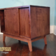 Solid cherry wood audio storage cabinet featuring an upper turntable and media equipment shelf. The lower section includes a media cabinet with two sliding doors and two divided storage compartments.