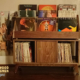 Solid walnut record storage cabinet with doors & 9-to-15 LP flip bin compartments, available from 42-to-70 inches. This vinyl stand 4-tier features upper forward facing bins above 3-to-5 divided compartments, all on tapered mid-century legs.