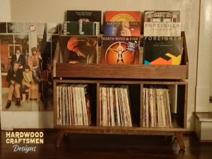 Large solid walnut record cabinet with 9 upper vinyl flip bins, six divided storage compartments, and tapered mid-century legs with crossbars.