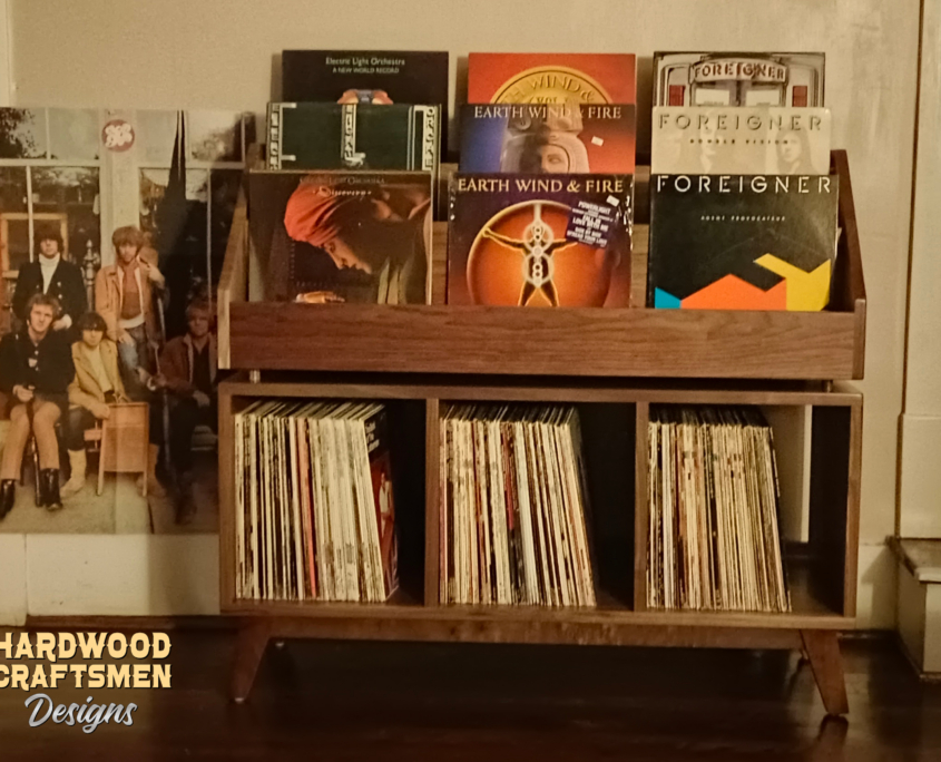 Solid walnut record cabinet with 9 upper vinyl flip bins, six divided storage compartments, and tapered mid-century legs with crossbars.