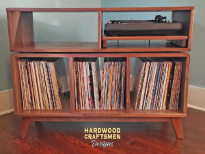 2-Level solid walnut media console featuring a pull-out turntable shelf, a media bay, three open record storage bins, and tapered mid-century legs.