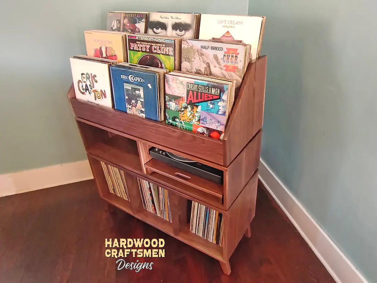 solid walnut record player stand with pullout turntable shelf, 3 vinyl storage bins, and 9 record flip bins, view of side.