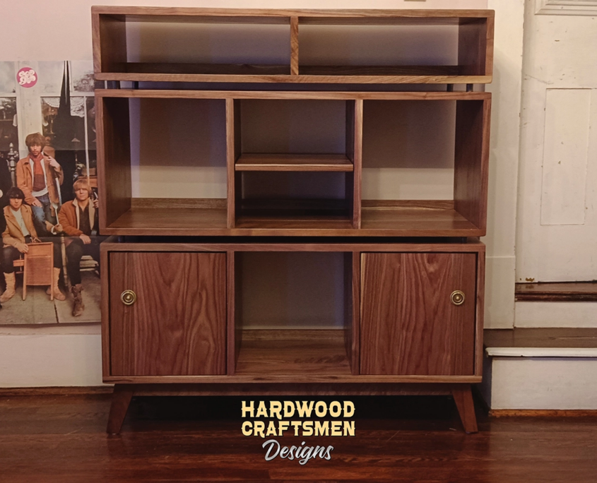 Solid walnut record storage cabinet with 2 doors 3 x 3 layout with 6 vinyl bin compartments, available from 42 to 72 inches. This audio bays & vinyl stand features upper media bays above six divided compartments, all on tapered mid-century legs.