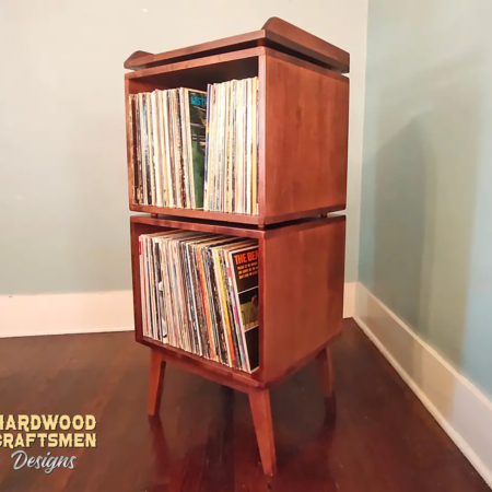 Solid cherry small record cabinet with a custom upper turntable station shelf, two stacked vinyl storage compartments, and tapered mid-century legs.
