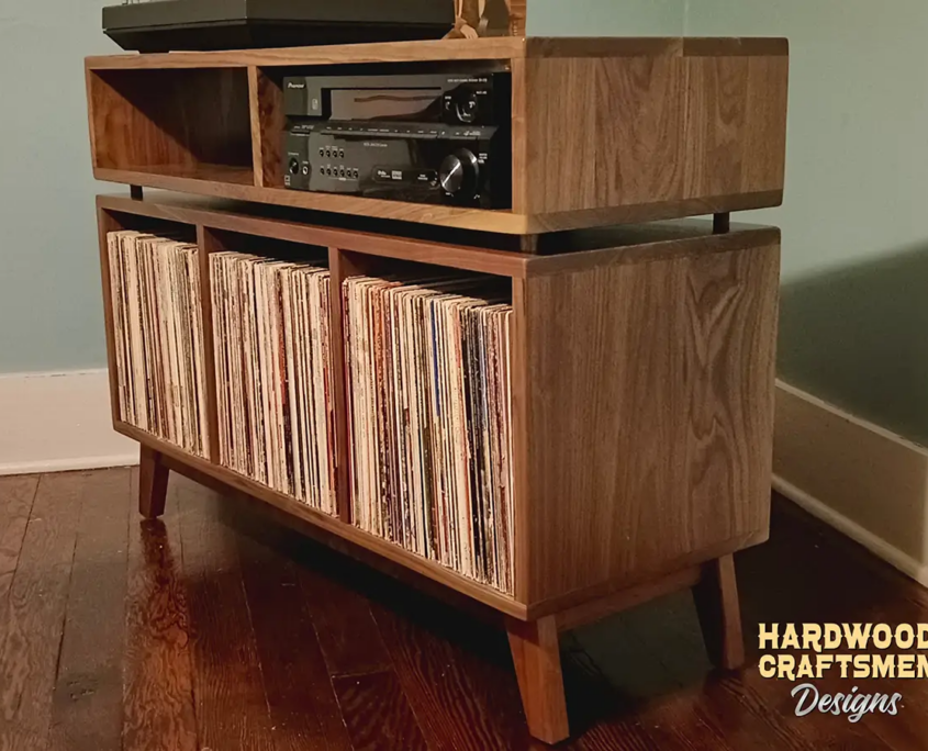 Solid walnut record player stereo console & vinyl storage with 3 bin compartments, available from 42 to 72 inches. This credenza cabinet features an upper TV shelf above three divided storage compartments, with two hardwood media bays, all on tapered mid-century legs.