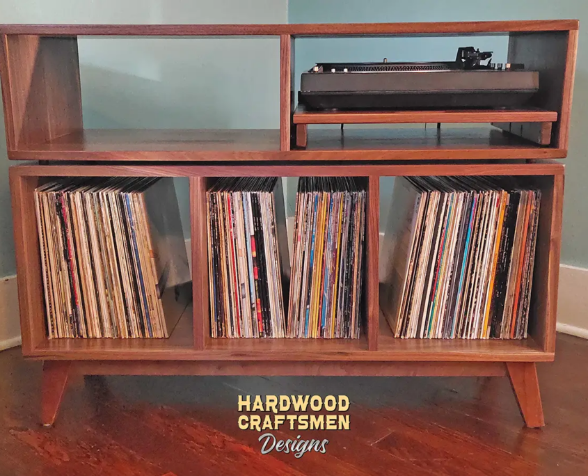 Solid walnut media cabinet featuring 3 vinyl compartments with a custom turntable pull out shelf and equipment bay above. This record player tv stand is available from 42 to 72 inches, all on tapered mid-century legs.
