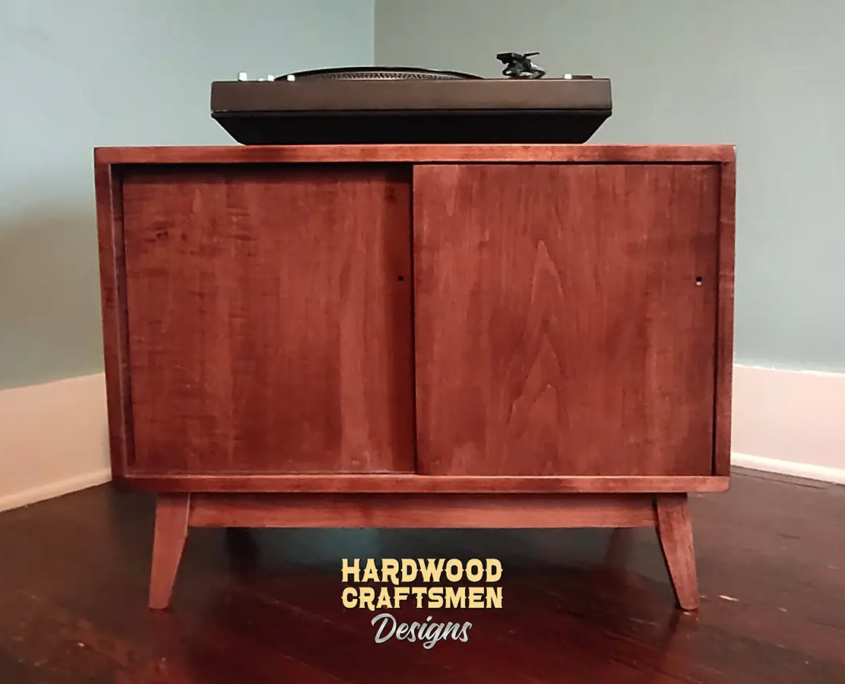Low profile solid wood record cabinet featuring an upper turntable and media equipment shelf. The lower section includes a media cabinet with two sliding doors and two divided storage compartments.