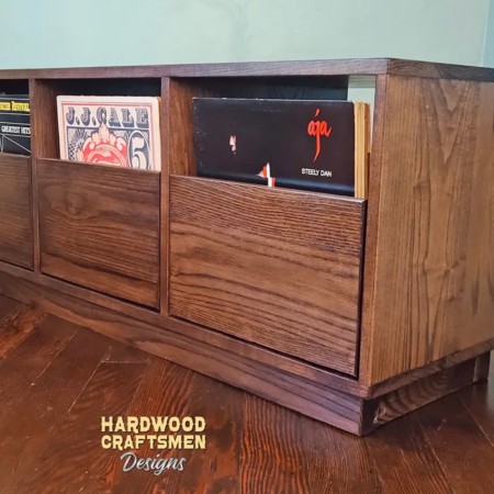 Dovetail 3 x 1 record storage cabinet features 3 pull out vinyl drawers below a turntable shelf. This LP player stand is available in solid walnut, ash, red oak, maple, cherry and oak, all on a 3 inch 100% hardwood plinth base.