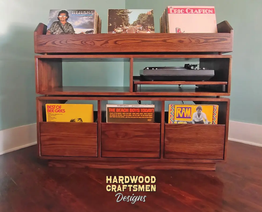 Dovetail 3 x 2.5 record player stand with equipment bays, 3 pull out vinyl storage drawers and 3 flip bins. This LP cabinet is available in solid walnut, ash, red oak, maple, cherry and oak, all on a 3 inch 100% hardwood plinth base.