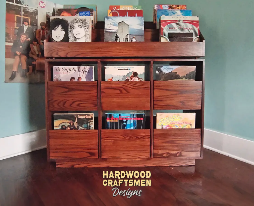 Dovetail 3 x 3 record storage cabinet features 6 pull out drawers below 9 LP flip bins. This vinyl stand is available in solid walnut, ash, red oak, maple, cherry and oak, all on a 3 inch 100% hardwood plinth base.