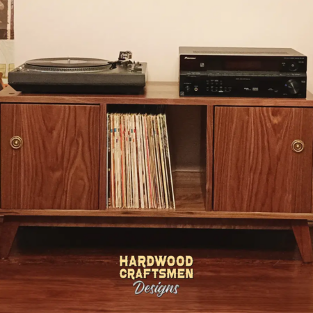 Solid walnut media console with doors, available from 42 to 72 inches, featuring an upper TV shelf above three divided storage compartments, with two outer hardwood doors covering the side compartments, all on tapered mid-century legs.